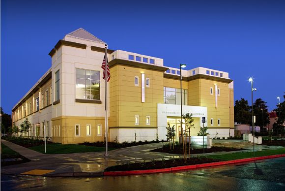 Modern church building with cross and clear blue sky.